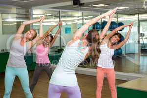 Yoga class in tree pose in fitness studio