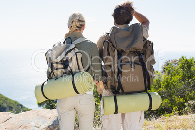 Hiking couple looking at the view on mountain summit