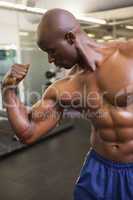 Muscular man flexing muscles in gym