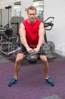 Strong man lifting heavy kettlebell
