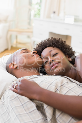 Happy couple lying in bed together Happy couple lying in bed together