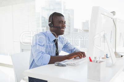 Happy businessman working at his desk wearing headset Happy businessman working at his desk wearing headset