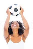 Pretty girl holding football and smiling