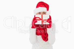 Festive woman looking at camera holding a gift