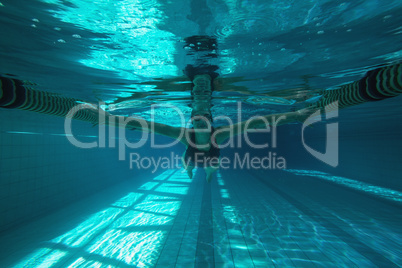 Athletic swimmer swimming towards camera