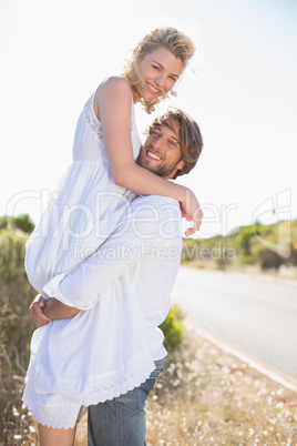 Attractive man lifting up his girlfriend smiling at camera