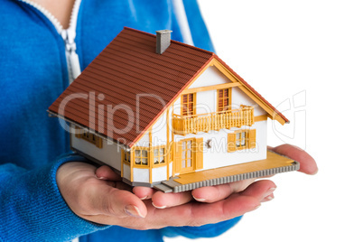 Hands holding miniature house model
