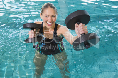 Fit blonde working out with foam dumbbells