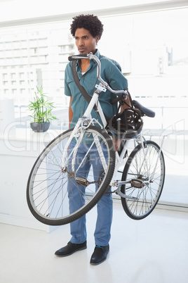 Handsome businessman standing with his bike