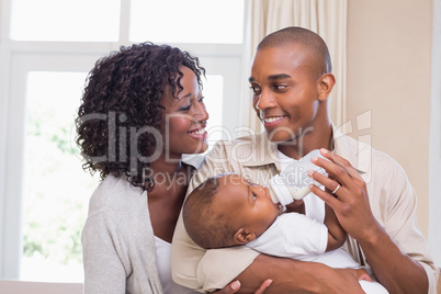 Happy parents feeding their baby boy a bottle