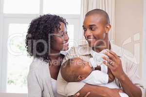 Happy parents feeding their baby boy a bottle