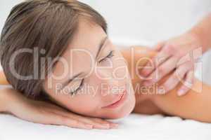 Attractive woman receiving shoulder massage at spa center