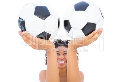Pretty girl holding footballs and smiling