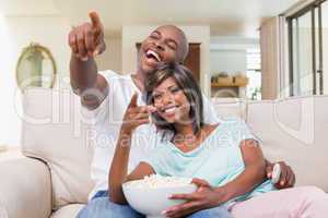 Happy couple relaxing on the couch watching tv