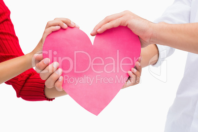 Couples hands holding pink heart