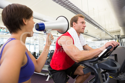 Personal trainer shouting at client through megaphone