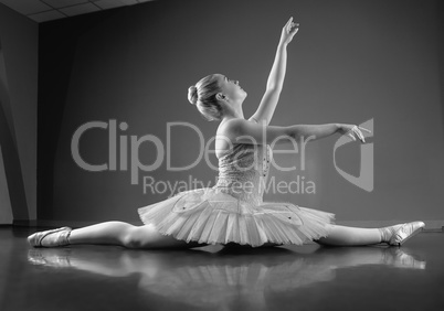 Graceful ballerina sitting with legs stretched out