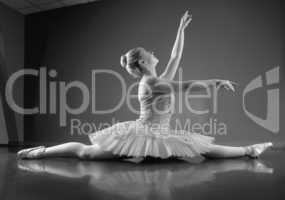 Graceful ballerina sitting with legs stretched out