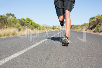 Fit man jogging on the open road