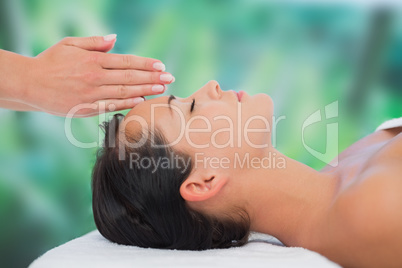 Beautiful brunette getting reiki therapy