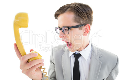 Geeky businessman shouting at retro phone