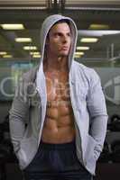 Muscular man in hood jacket at gym