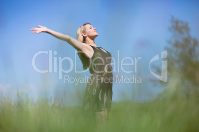 Pretty blonde in sundress standing with arms out