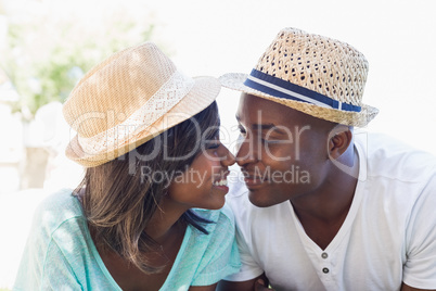 Happy couple lying in garden together touching noses