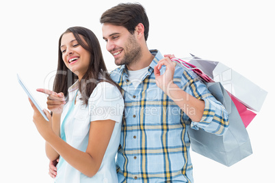 Attractive young couple with shopping bags and tablet pc