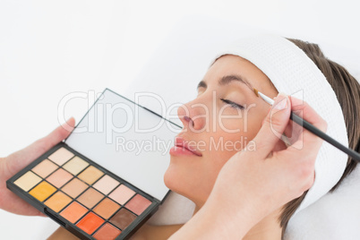 Hand applying eyeshadow to beautiful woman