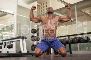 Muscular man flexing muscles in gym