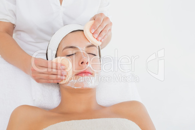 Hand cleaning womans face with cotton swabs