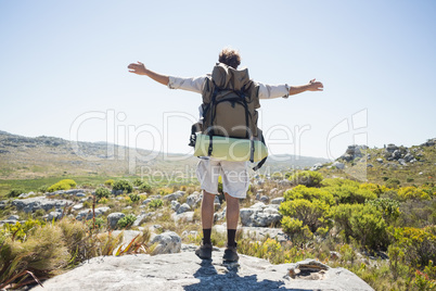 Hiker standing at the summit with arms outstretched