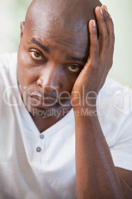 Upset man sitting on the couch looking at camera