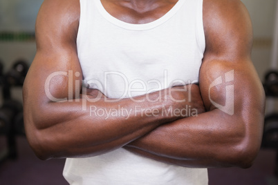 Mid section of a muscular man with arms crossed