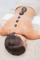 Beautiful woman receiving stone massage at spa center