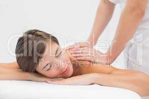 Attractive woman receiving shoulder massage at spa center