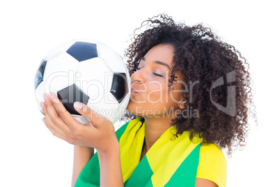 Pretty football fan with brazilian flag kissing ball
