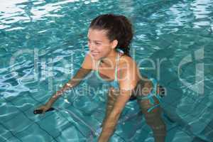 Fit brunette using underwater exercise bike