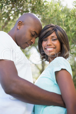 Happy couple hugging each other in garden