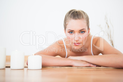 Peaceful blonde lying on bamboo mat