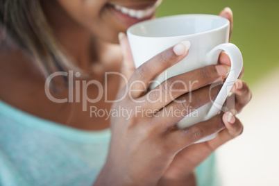 Smiling woman having coffee outside