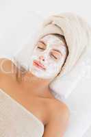 Attractive having white cream on her face at spa center