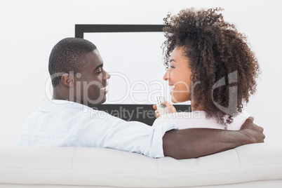 Couple sitting on couch together watching tv