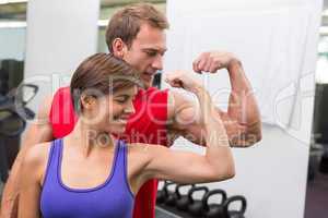 Fit attractive couple flexing their biceps