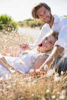 Attractive couple relaxing in the countryside smiling at camera