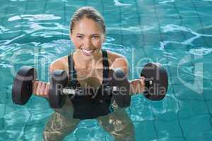 Fit blonde working out with foam dumbbells