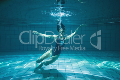 Athletic swimmer smiling at camera underwater