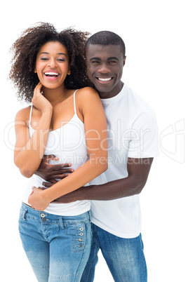 Casual couple embracing and smiling at camera