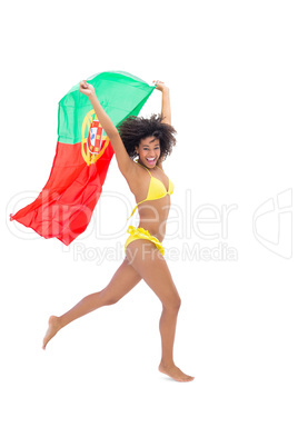 Fit girl in yellow bikini holding portugal flag laughing at came
